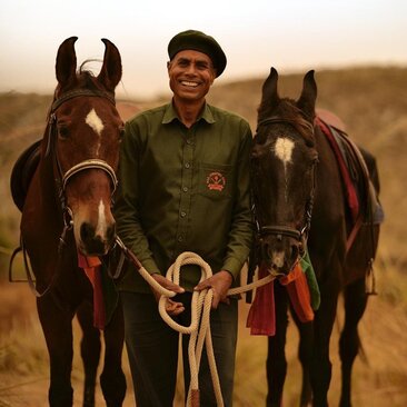 Man holding two Marwari horses in the Rajasthani desert at Aman-i-Khas.