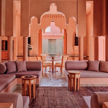 Grand Two-Bedroom Pool Villa lounge at Amanjena resort, Morocco, with symmetrical terracotta archways and seating areas.