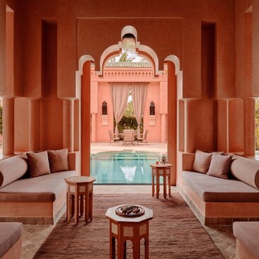 Grand Two-Bedroom Pool Villa at Amanjena resort with terracotta walls, sunken plunge pool, and symmetrical seating areas.