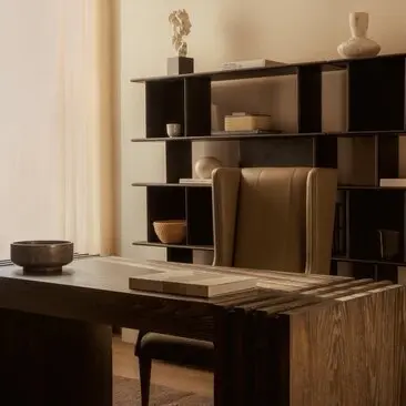 Office in a three-bedroom penthouse at Aman New York, featuring a wooden desk and geometric shelving unit.