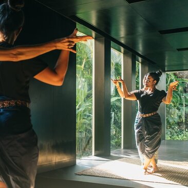 Apsara dance class at Amansara's Movement Studio, with instructor and participant in traditional dress near open doors.