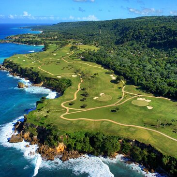 Aerial view of Playa Grande Golf Course at Amanera resort, with fairways stretching along dramatic coastline and turquoise waters.