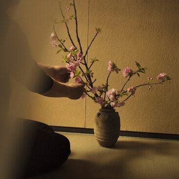 Ikebana arrangement with delicate branches in dark ceramic vessel at Aman New York.