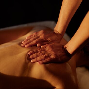 Mains reposant sur une surface d'eau dorée lors d'un soin au spa d'Amanera, resort en République dominicaine.