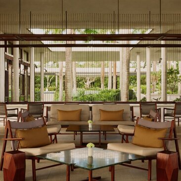 Salon lounge du bar à Amanera Resort, République dominicaine, avec baies vitrées et mobilier en bois.