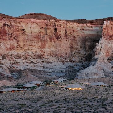 Camp Sarika at Amangiri nestled beneath towering red rock cliffs in the Utah desert.