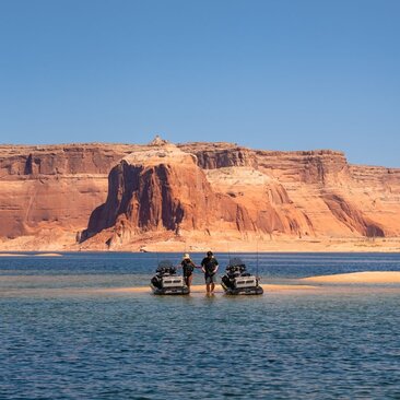 Boat on Lake Powell with red rock cliffs at Amangiri resort, Utah.