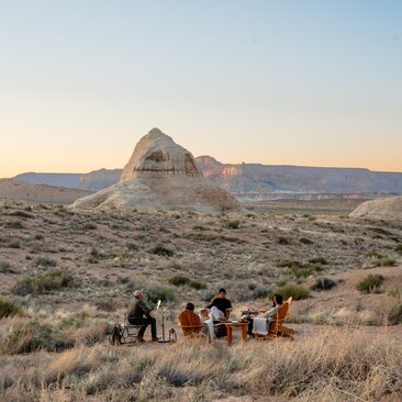 Gruppo di ospiti cammina al tramonto nel paesaggio desertico di Amangiri.