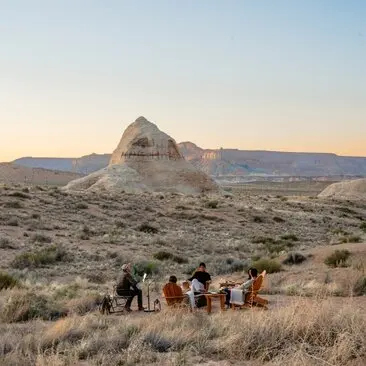 Group of hikers on desert trail at sunset, Amangiri, Utah.