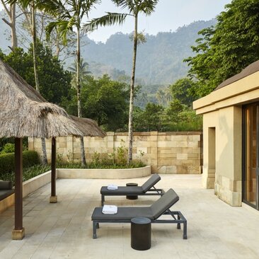 Amanjiwo garden pavilion with thatched-roof seating area and mountain views, Indonesia.