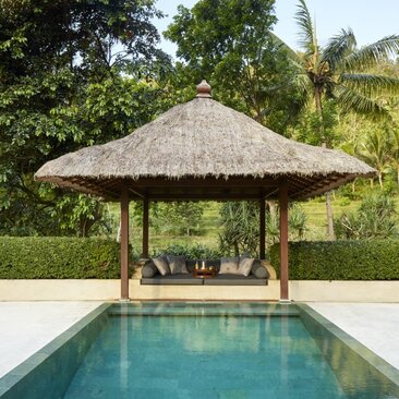 Menoreh Pool Pavilion at Amanjiwo, Indonesia, with thatched roof overlooking a still plunge pool and verdant surroundings.
