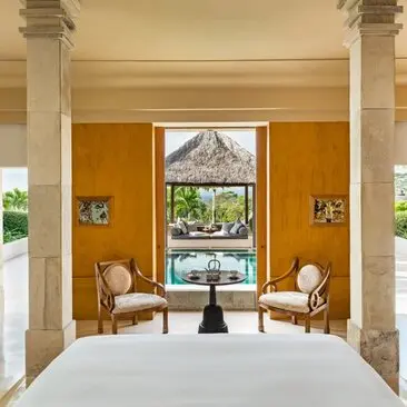 Pandangan dari tempat tidur Suite Taman ke paviliun kolam renang di Amanjiwo, Indonesia.