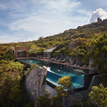 Ocean pool residence at Amanoi, Vietnam, surrounded by verdant hillside and limestone cliffs.