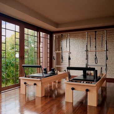 Salle de Pilates avec mobilier en bois naturel et baies vitrées, Amanpulo resort, Philippines.