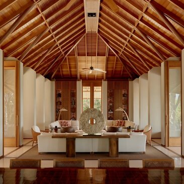 Living area at Amanyara villa with vaulted wooden ceiling and central seating arrangement.