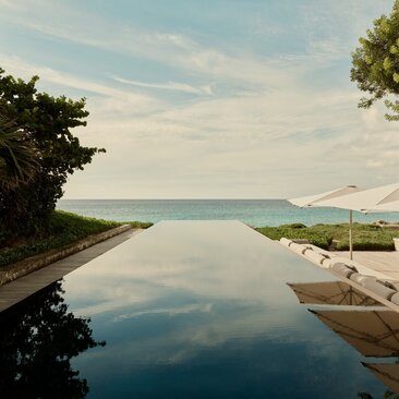Outside living area at Amanyara villa with infinity pool overlooking calm turquoise waters and distant islands.
