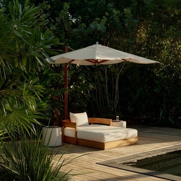 Amanyara villa jacuzzi with cream parasol and cushioned seating surrounded by tropical foliage.