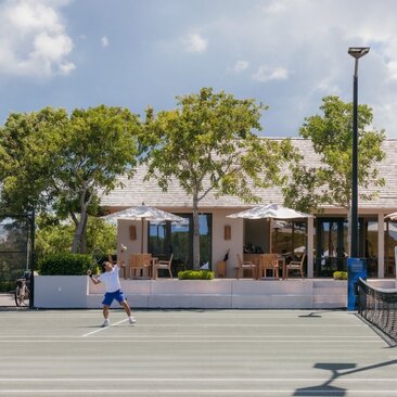 Tennis court at Amanyara's clubhouse with player in action, Turks and Caicos.