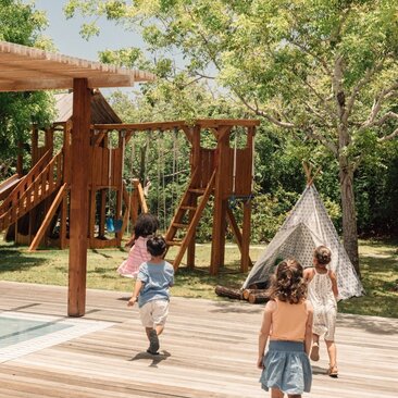 Children exploring wooden play structures at Amanyara's Nature Discovery Centre in Turks and Caicos.