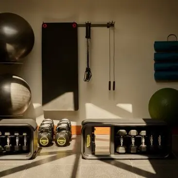 Amanyara spa and wellness gym with exercise equipment, weights, and wellness products arranged on shelving.