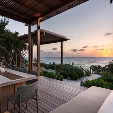 Beach sala at Amanyara at sunset, overlooking turquoise waters and horizon.