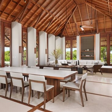 Dining area of a four-bedroom villa at Amanyara, Turks and Caicos, with wooden ceiling beams and coastal views.