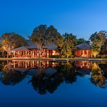 Amanyara five-bedroom villa exterior reflected in still water at dusk, Turks and Caicos.