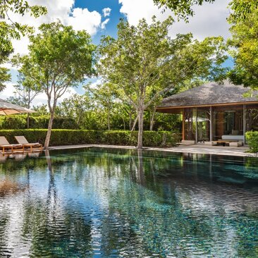 Amanyara five-bedroom villa with infinity pool reflecting surrounding tropical trees and open-air pavilion.