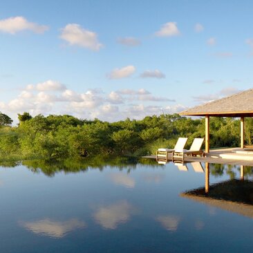 Ocean-view villa at Amanyara with private jetty overlooking calm turquoise waters and tropical mangrove landscape.