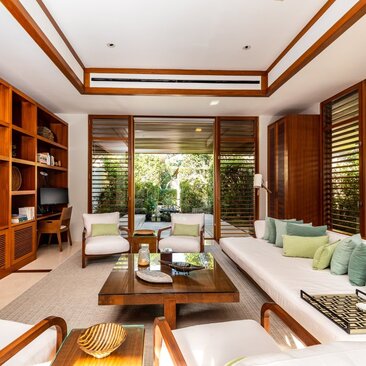 Six-bedroom villa at Amanyara with open-plan living area, wooden furnishings, and garden views.