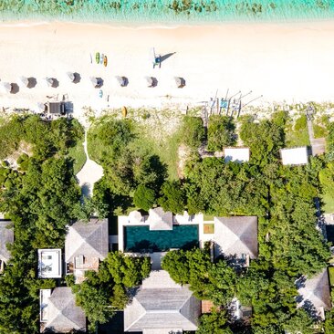 Aerial view of Amanyara six-bedroom villa surrounded by tropical vegetation and beachfront in Turks and Caicos.