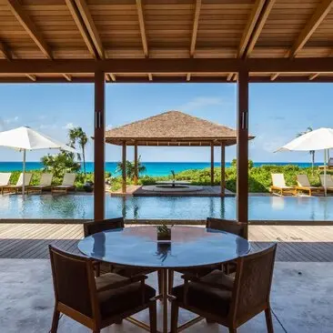 Four-bedroom ocean villa at Amanyara with infinity pool overlooking turquoise waters and mountain vista.