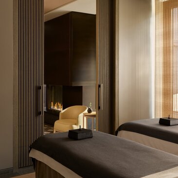 Spa treatment room at Aman New York with massage bed and warm lighting alcove.