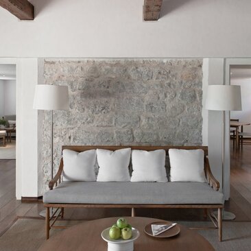 Adriatic Suite lounge at Aman Sveti Stefan with contemporary seating and textured stone accent wall.