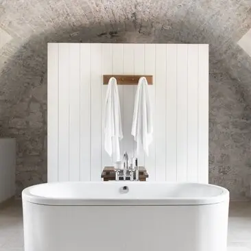 Deluxe cottage bathroom at Aman Sveti Stefan with minimalist white vanity and wooden towel rail.