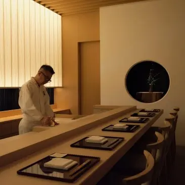 Salle de réunion épurée à Aman Tokyo, avec table en bois et mobilier minimaliste.