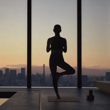 Silhouette of a person practising yoga at Aman Tokyo hotel, standing by floor-to-ceiling windows overlooking the city at sunset.