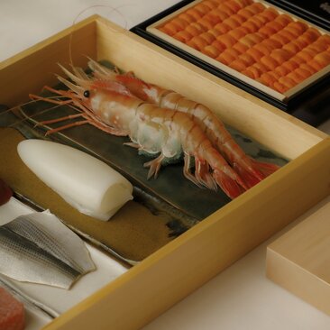 Sushi-making class at Aman Tokyo: fresh prawn and ingredients arranged in wooden box.