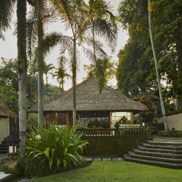 Amandari one-bedroom villa garden with traditional thatched pavilion, palm trees and manicured lawn.