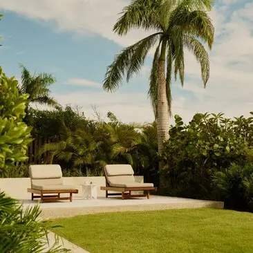 Hill Casita garden with lawn, palm trees and lounge seating at Amanera resort, Dominican Republic.