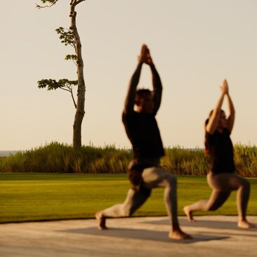 Deux personnes pratiquent le yoga en plein air à Amanera, la station balnéaire dominicaine.