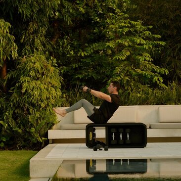 Homme pratiquant le yoga sur une plateforme en béton entourée de végétation luxuriante à Amanera, resort en République dominicaine.