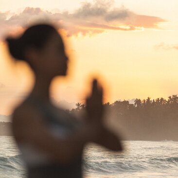 Silhouette of a person practising yoga at sunset by the beach at Amanera resort, Dominican Republic.