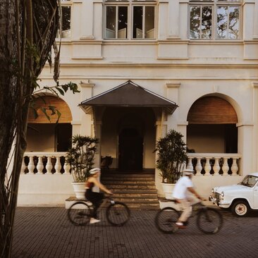 Two cyclists ride past the colonial-era facade of Amangalla in Galle, Sri Lanka.