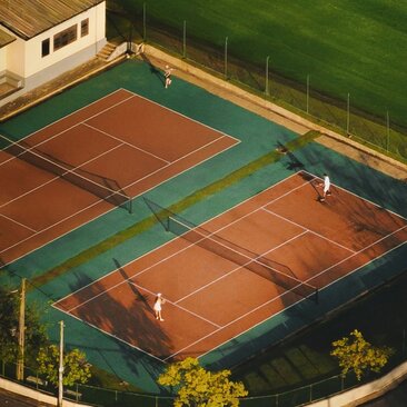 Tennis courts at Amangalla, Sri Lanka, with clay surfaces bordered by green surrounds and manicured grounds.
