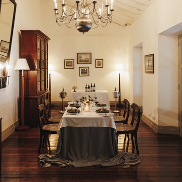 Chef's table dining room at Amangalla with round table, wooden chairs, and chandelier overhead.