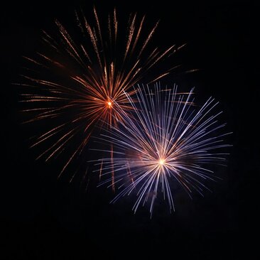 Fuochi d'artificio rossi e blu esplodono nel cielo notturno sopra Amangiri resort, USA.