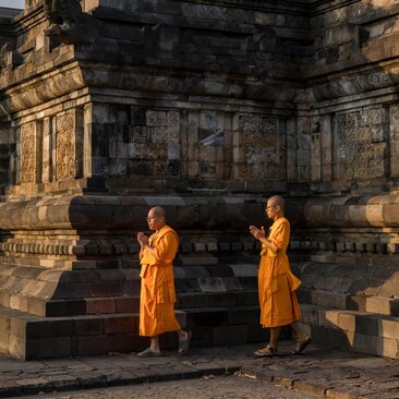 Two Buddhist monks in saffron robes at Amanjiwo resort during Kirab Vesak ceremony, Indonesia.