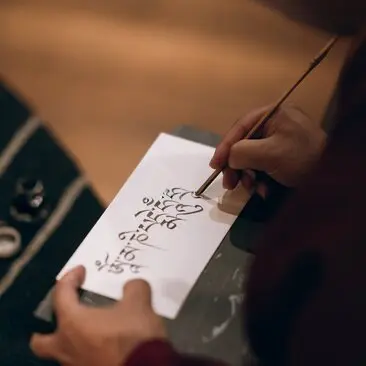 Hand practising traditional Bhutanese calligraphy at Amankora, Paro Lodge.