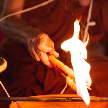Buddhist monk blessing ceremony at Amantaka, Laos, with candles burning in candlelight.